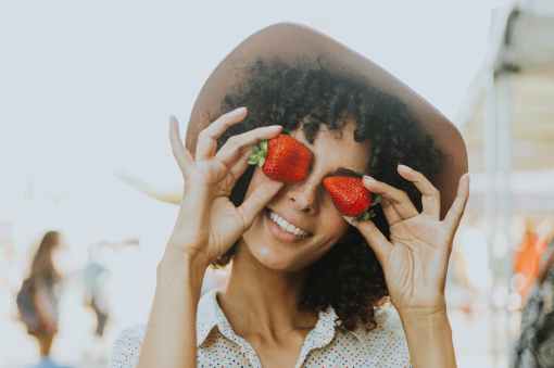 woman holding two strawberries